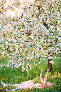 春日 在盛开樱花树花园的可爱小女孩园艺童年女孩享受森林公园乐趣生活花园裙子图片