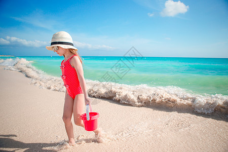 在热带度假期间玩沙滩玩具的小女孩 热带假期晴天情调女儿女孩孩子海岸乐趣海洋异国闲暇图片