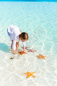 可爱的小女孩 有海星在清水的水中图片