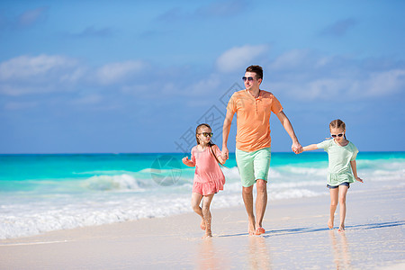 家庭在卡里比岛的白色热带海滩上行走女孩跑步父母喜悦海景海岸线海洋异国假期爸爸图片