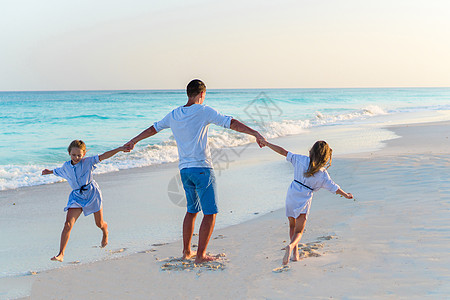 家人晚上在卡利比恩岛白沙滩上行走女性跑步海岸线爸爸假期父母男人喜悦情感女士图片