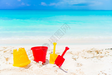 小孩在白沙沙滩上的海滩玩具 在海面背景图片