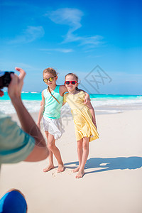 父亲拍下他女儿的照片 在卡里比岛的白色热带海滩上 玩得很开心图片