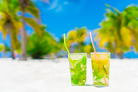 在棕榈林的白沙滩上 两杯冰冷美味的莫希托鸡尾酒蓝色海岸线薄荷海岸奢华海滩海滨玻璃棕榈果汁图片