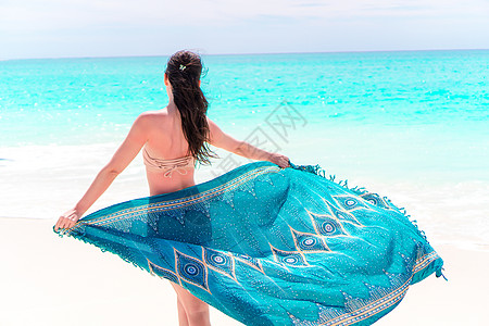 美丽的比基尼身体女人放松 在水流的遮蔽海滩时装包装中 以海洋日落的背景日光浴游泳衣享受蓝色情调旅游自由皮肤闲暇披肩图片