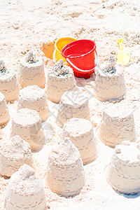 白沙滩上的沙堡 有塑料小孩玩具和海背景旅行艺术假期情调建筑气候乐趣雕塑海岸异国图片