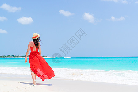 热带沙滩度假时戴帽子的年轻女青年享受海滩旅行海岸游客蓝色支撑异国女士低潮图片