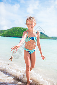 快乐的小女孩在浅水中漂浮和玩得开心 穿着泳衣的孩子在玩沙子热带旅行情调运动天堂飞溅享受海洋海景童年图片