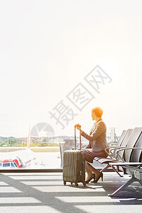 商业女商务人士在机场等待登机时静坐的肖像职业下载窗户椅子女性旅行女士行李国际商务图片