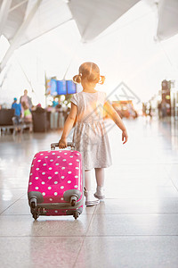 年轻的可爱小女孩的肖像 带着粉红色手提箱在机场跑来跑去飞机场航班飞行童年国际女孩飞机游客闲暇父母图片