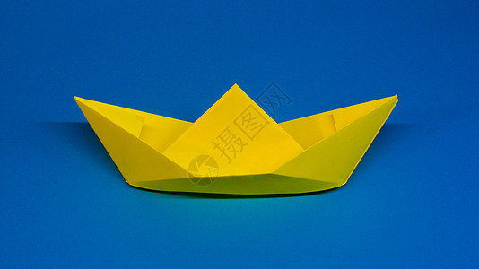折纸黄色纸船在蓝色图片