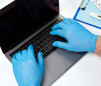 蓝乳胶医疗手套专家医生 在膝盖上工作从业者临床屏幕蓝色职业技术电脑医院保健互联网图片