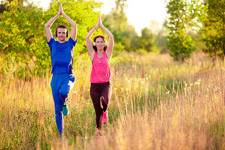 微笑的年轻夫妇在户外锻炼运动女孩公园家庭耳机身体夫妻短跑运动装赛跑者享受图片