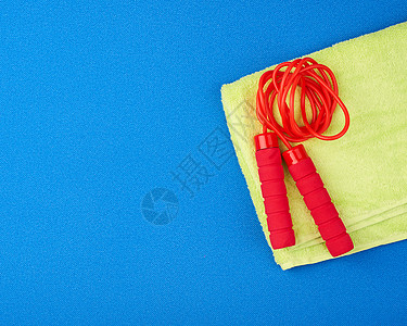 红色的跳绳在新青蓝运动垫子上活动绳索童年电缆训练有氧运动工具蓝色健身房闲暇图片