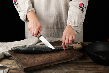身穿灰色内衣的女子清洗鱼海贝斯低音海鲜木板砧板圆形烹饪美食厨房黑色木头图片