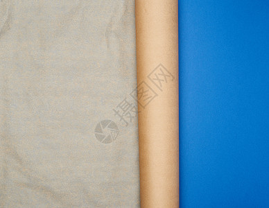 蓝色背景上的一卷棕色羊皮纸copy spac海浪商业笔记家庭折叠纸板边缘床单标签角落图片