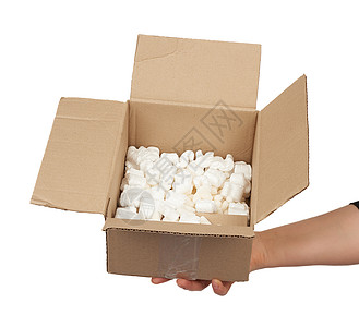 女性手握着一盒空开的棕色纸板货物盒子回收商业工艺泡沫送货货运包装邮件图片