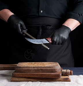 穿黑衬衫和黑色乳胶手套的厨师磨厨房用具金属刀刃餐厅男人烹饪工作室美食夹克男性图片