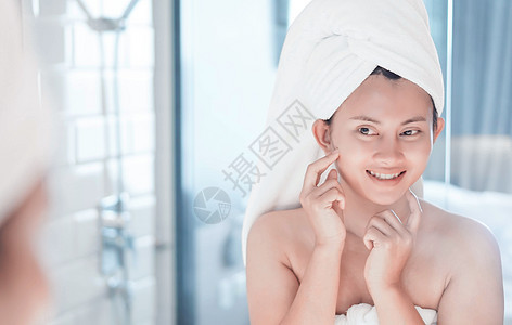 近视的女人看着她的脸 在镜子中微笑 然后温泉粉刺奶油反射淋浴身体洗澡毛巾成人女孩图片