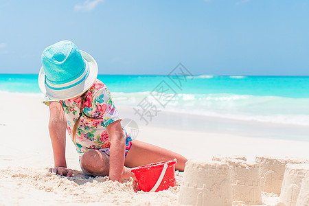 在热带度假期间玩沙滩玩具的可爱小女孩 热带假期女孩异国闲暇海洋海岸女儿海滩沙堡童年快乐图片