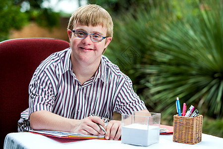 残疾人男孩在花园的桌子上图片