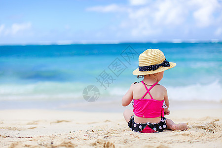 热带白沙滩的小女孩 造沙城堡海岸游泳衣太阳孩子们乐趣家庭童年海岸线玩具婴儿图片