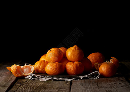 一大堆未穿过的圆圆熟橙橘色芒达林 在灰亚麻布小便袋上乡村盘子黄色营养热带圆形甜点果汁水果橙子图片