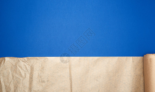 蓝色背景上未扭曲的棕色羊皮纸卷图片