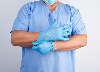 穿蓝制服的男男性医生将白衣晚育手套医师专家橡皮诊所药品手指护士乳胶卫生图片