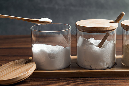 木制桌上玻璃瓶中的调味品勺子盐瓶收藏香料厨房烹饪白色玻璃木头味道图片