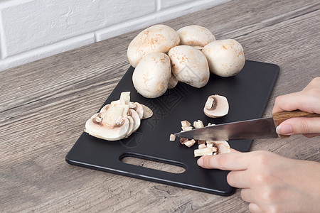 手在黑板上用刀切蘑菇 食物图片