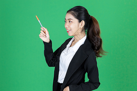 有吸引力的亚洲年轻商业女性 持有笔和想法 冒充绿色孤立的背景 肖像照耀图片