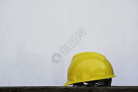 建筑头盔 木制桌上的黄色安全头盔图片