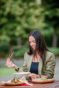 吃东西的年轻女人 在街上把面条抢走游客筷子生活美食午餐女士烹饪菜单用餐顾客图片