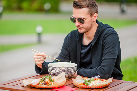 吃饭的年轻人在街上抢走面条电话餐厅服务街道旅行游客城市桌子美食筷子图片