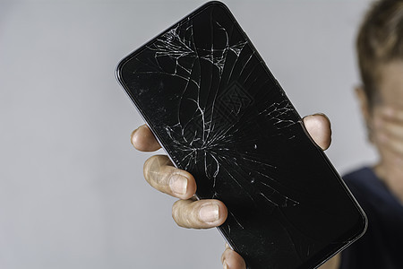 手持灰色背面智能电话触摸屏幕破碎的妇女女士网络破坏触摸屏裂缝维修粉碎展示玻璃事故图片