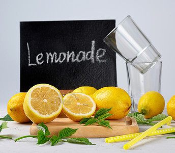 新鲜成熟的全黄柠檬和黑框 有正本叶子框架玻璃农业水果果汁木头桌子收成厨房图片
