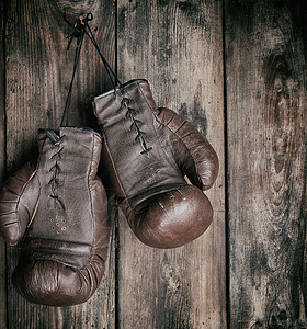 非常旧的皮革棕色拳击手套挂在破旧的木头上古董指甲竞赛活动斗争绳索运动装拳头盒子拳击手图片