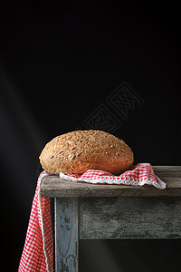 烤圆黑麦面包就躺在红色的纺织餐巾纸上图片