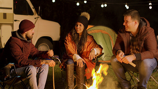一群亲密朋友在秋天寒冷的夜晚 在营火周围一起放松营地森林故事朋友们胡子火焰帐篷时间露营者灯泡图片
