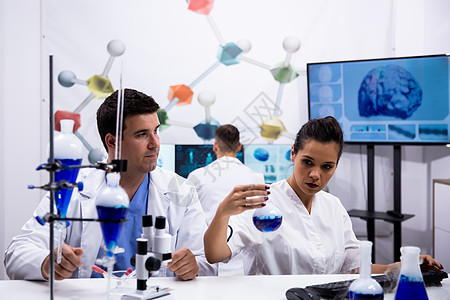 年轻科学家在研究实验室穿白大衣的年轻科学家图片