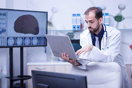 持有笔记本电脑的医生将其专业知识传授给另一名医生图片