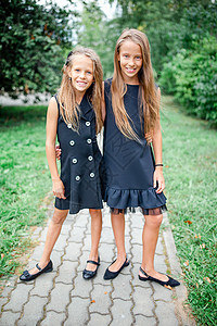 两个可爱的小女孩 在学校门口摆着姿势 装模作样小学生活力学习娱乐公园女孩童年大学友谊喜悦图片