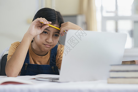 快乐的亚洲女孩在家网上学习练习远程教育瞳孔学生时间课程网络数字孩子们家庭作业图片