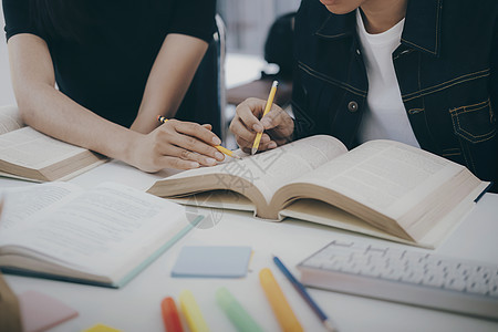 年轻学生校园帮助朋友追赶和学习 并帮助他们学习团体笔记同学写作公司课程班级教育学校课堂图片