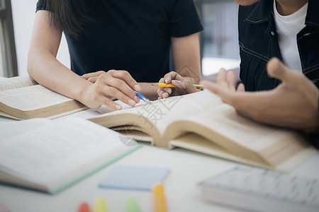 年轻学生校园帮助朋友追赶和学习 并帮助他们学习阅读教科书学者考试知识青少年笔记本课堂班级公司图片