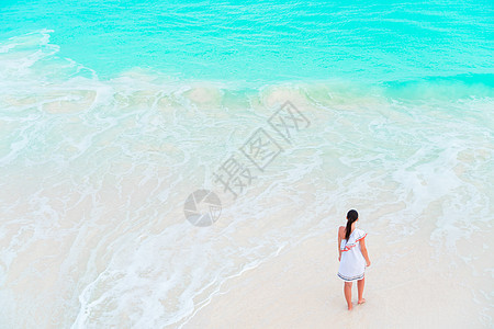 海滩快乐女孩 在浅水里玩得很开心热带幸福童年享受海岸线情感海岸海景乐趣蓝色图片