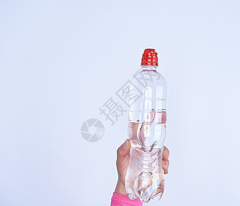透明塑料瓶 用清水装在女性手中红色塑料工作室液体瓶子女孩白色女士饮料茶点图片