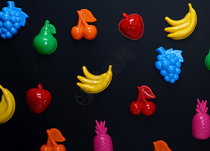 黑色背景的多色塑料玩具制品果实收藏孩子水果橙子框架香蕉蓝色婴儿乐趣童年图片