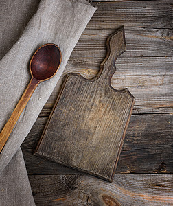 旧的棕色木制木勺和切割板图片